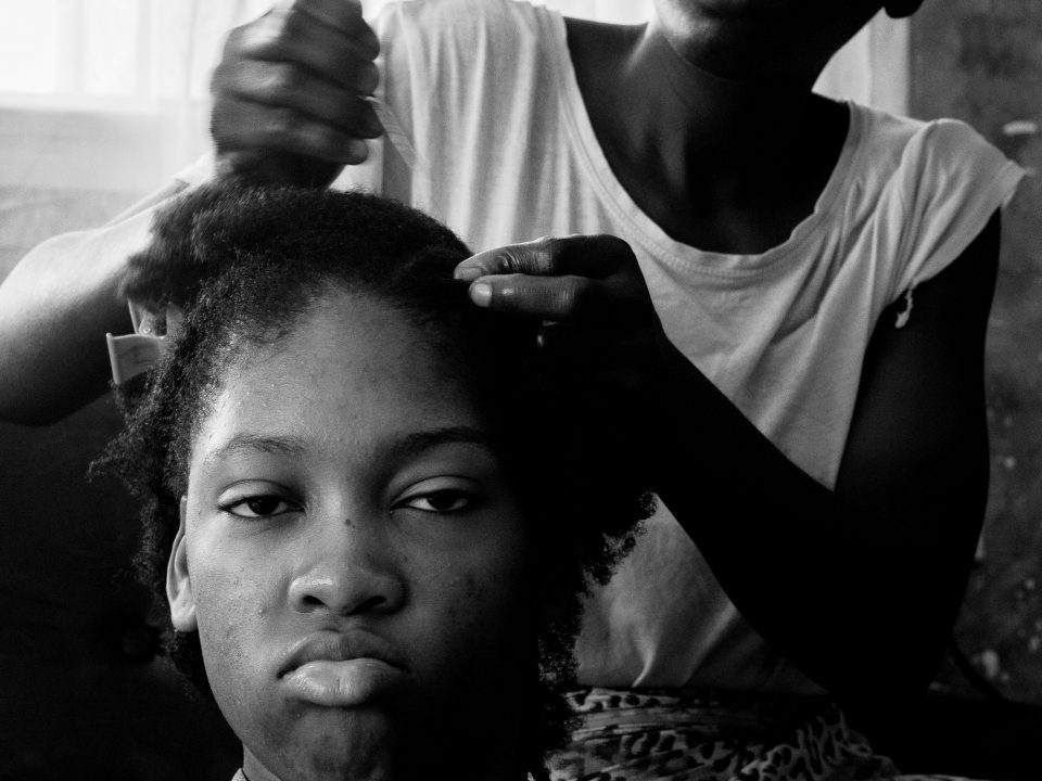Mother combing daughter's hair.